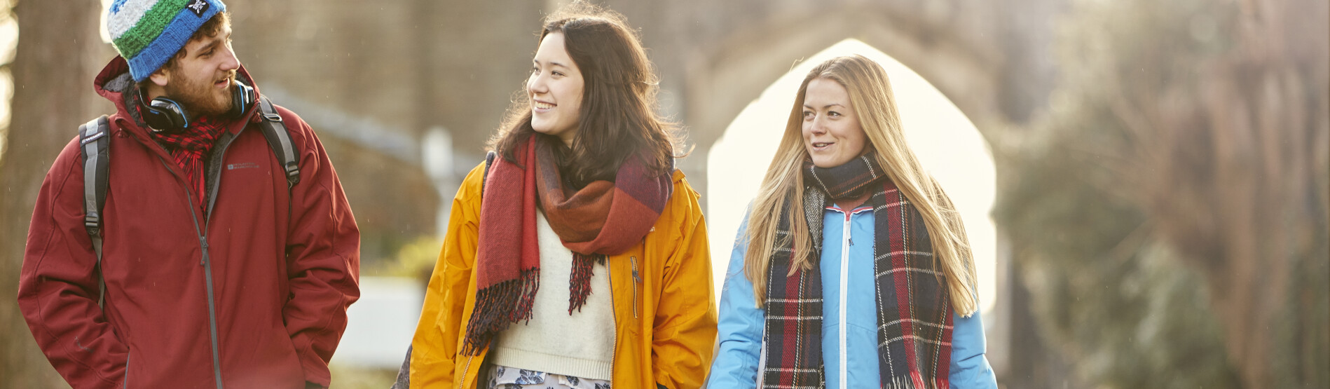 Three students in Winter clothing walking in Singleton Park