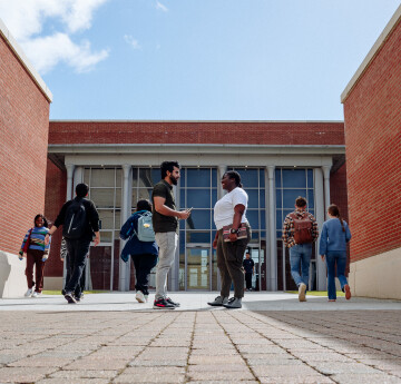 Students coming and going in front of the Bay Library entrance