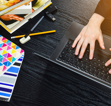 Hands typing on a laptop keyboard