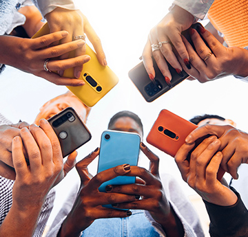 People standing in a circle using smartphones