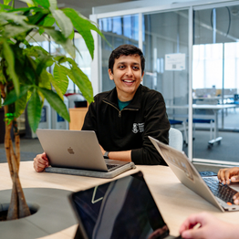 A Swansea university student sitting at a desk with a laptop.