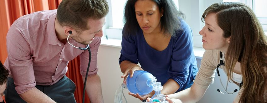 Students and lecturer working on dummy