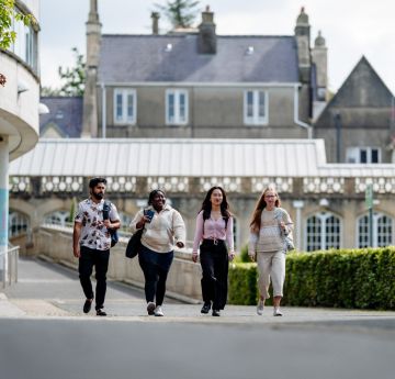 Myfyrwyr yn cerdded lawr y mall