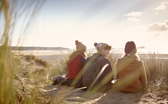 three people sitting on beach