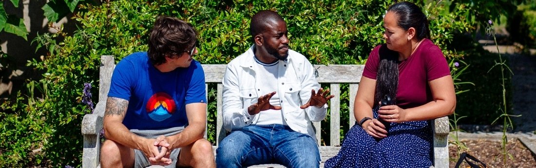Students on a bench socialising near the Abbey on Singleton Campus
