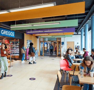 Students walking through a bustling area of Fulton House