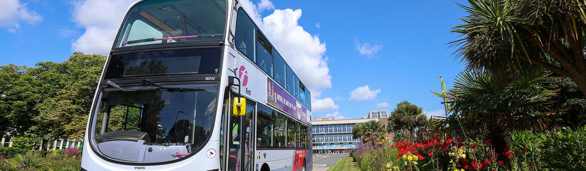 A First Bus driving down the main driveway on Swansea University's Singleton Campus. Fulton House is in the background