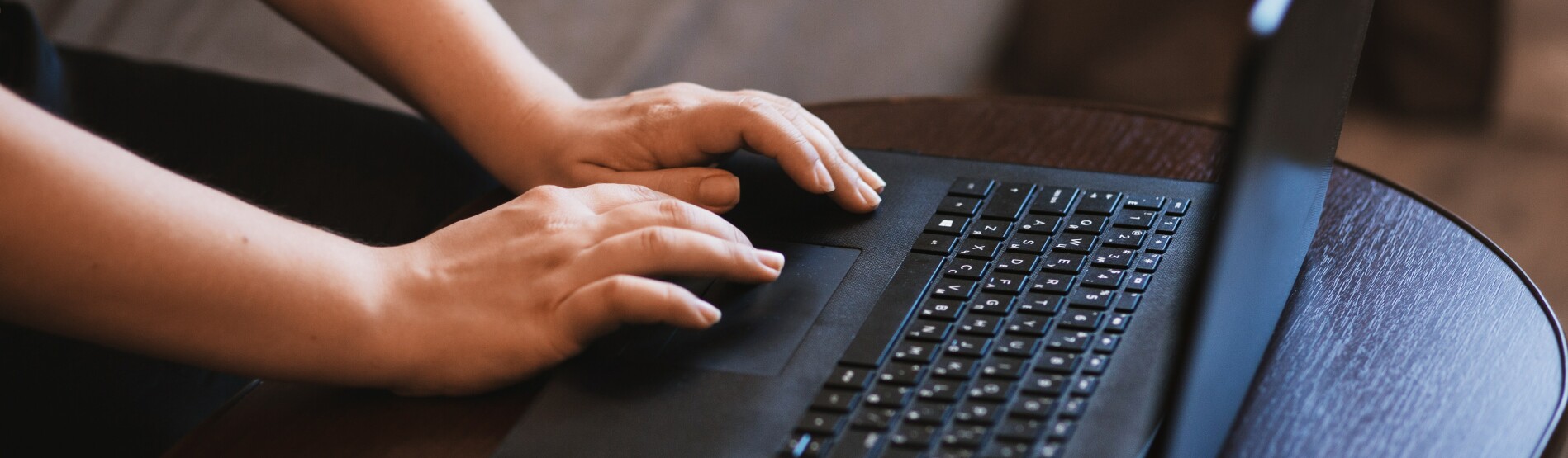 Hands typing on a laptop