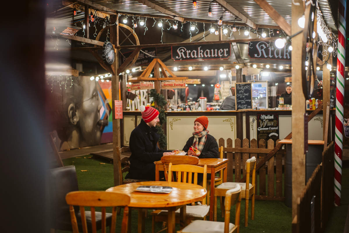 2 people sat at the Christmas Market