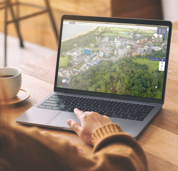 a laptop showing a Swansea Uni virtual tour