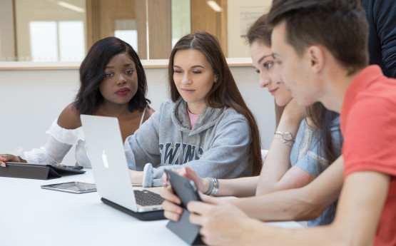 Three students working together at a laptop
